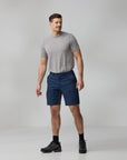 Man wearing a gray t-shirt and blue shorts on a plain background