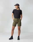Person wearing a black t-shirt, green shorts, and a cap on a white background