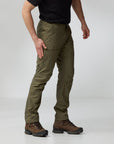Person wearing olive green pants and brown boots on a white background