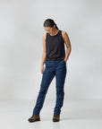Person wearing a black sleeveless top and blue pants on a white background