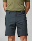 Person wearing dark gray shorts and a green shirt on a plain background
