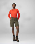 Person wearing an orange long-sleeve shirt, green shorts, and brown boots on a white background