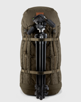 Brown backpack with a camera tripod attached on a light gray background