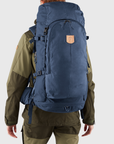 man carrying storm-dark navy trekking backpack with arctic fox logo