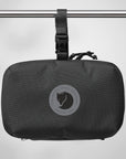 Black travel pouch with a Fjällräven logo on a gray background