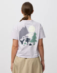 Person wearing a white t-shirt with nature-themed design on the back, standing against a plain background.