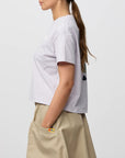 Person wearing a white t-shirt and beige pants on a light gray background