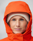 woman wearing orange padded windbreaker jacket with hood