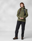 woman in green windbreaker jacket with hood and black trousers