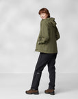 woman in green windbreaker jacket with hood and black trousers