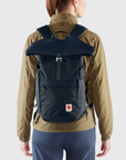 woman carrying navy foldtop backpack