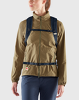 woman carrying navy foldtop backpack