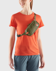 woman carrying green waist bag with a visible Fjällräven logo