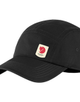 A black cap with a small reflective Fjällräven logo on the front.