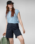 woman in light blue top and navy Bermudas shorts