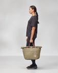 Person holding a beige bag against a white background