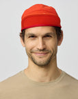 Man wearing a red cap against a plain background
