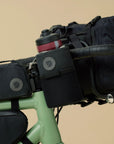 Bicycle with black bags and a water bottle on a beige background