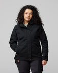 Woman wearing a black jacket on a gray background