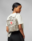 Person wearing a patterned backpack with a visible Fjällräven logo on a plain background