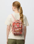 Person wearing a red and orange camouflage backpack with a visible brand logo on a light gray background