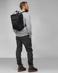 man carrying black Kanken backpack with Fjällräven logo