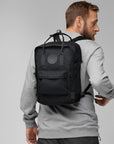 man carrying black Kanken backpack with Fjällräven logo