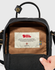 Black backpack with a visible Fjällräven label on a light gray background