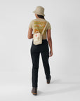 woman carrying a white sling bag with Fjällräven Kånken logo