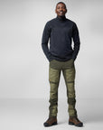 man wearing dark blue sweater and green trekking trousers