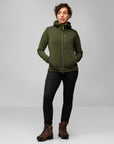 woman in green fleece jacket with hood and black trousers
