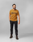 man in a acorn white round neck t-shirt with black trousers