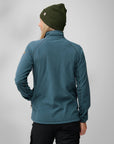 woman wearing blue fleece jacket and green beanie