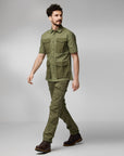 man wearing green collared shirt with pockets and green trekking trousers