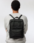 man carrying a black backpack with Fjällräven logo