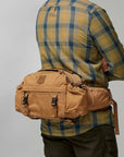 man carrying brown waist pouch with several compartments
