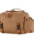 A brown hip pack with multiple compartments and adjustable straps, suitable for trekking or outdoor activities.
