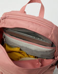 Pink backpack with compartments containing a laptop, yellow item, and gray item on a white background