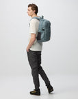 Person wearing a gray backpack on a white background