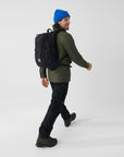 man carrying black backpack