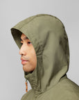 man wearing green windbreaker jacket with a hood