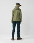woman wearing green jacket with hood with navy pants
