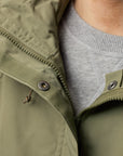 Close-up of a green jacket with a gray shirt underneath