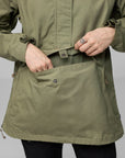 Green jacket with a focus on the front pocket against a gray background
