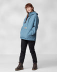 woman wearing dawn blue waterproof rain jacket with Fjällräven logo black trousers