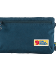 A navy Fjallraven bag with a zippered main compartment and a smaller zippered security pocket on the back. The bag features a label with the Fjallraven logo.