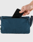 putting a phone into a navy pouch small bag