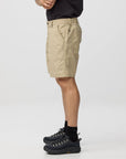 Person wearing beige shorts and black hiking boots on a white background