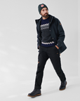 man in black windbreaker jacket with hood and black trousers