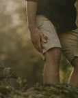 man touching his knees wearing a fossil colour bermudas shorts